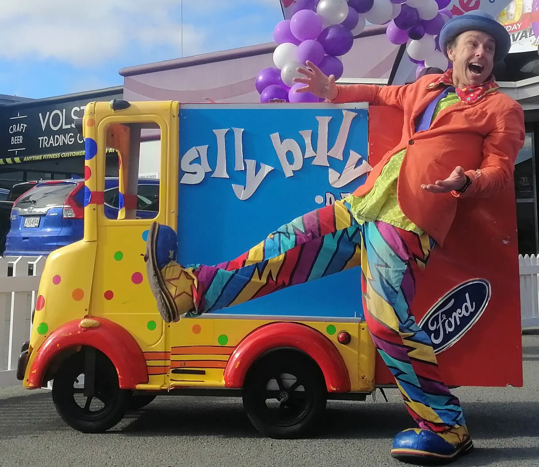 Silly Billy doing close-up roving magic for small groups of kids and families at an outdoor festival